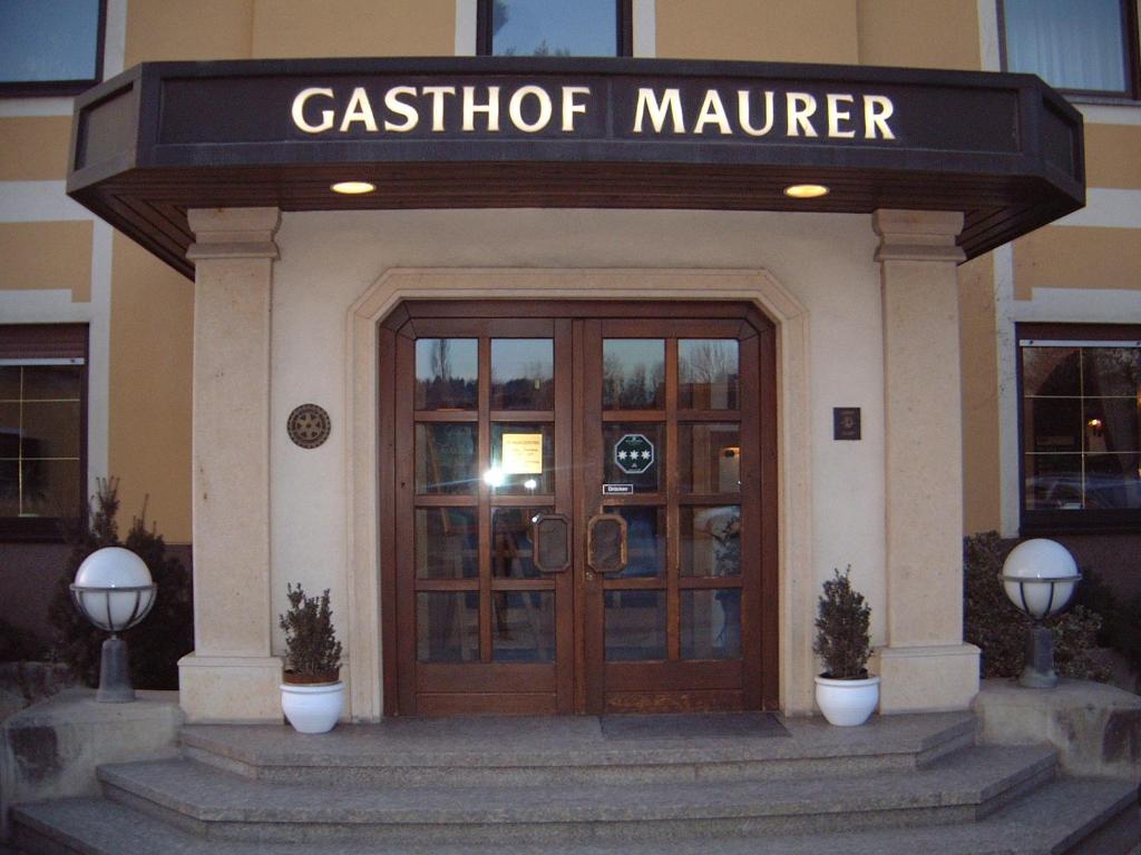 ein Gebäude mit einer Tür mit einem Schild, das den Cafeteria-Manager liest in der Unterkunft Maurer Gasthof-Vinothek in Gleisdorf