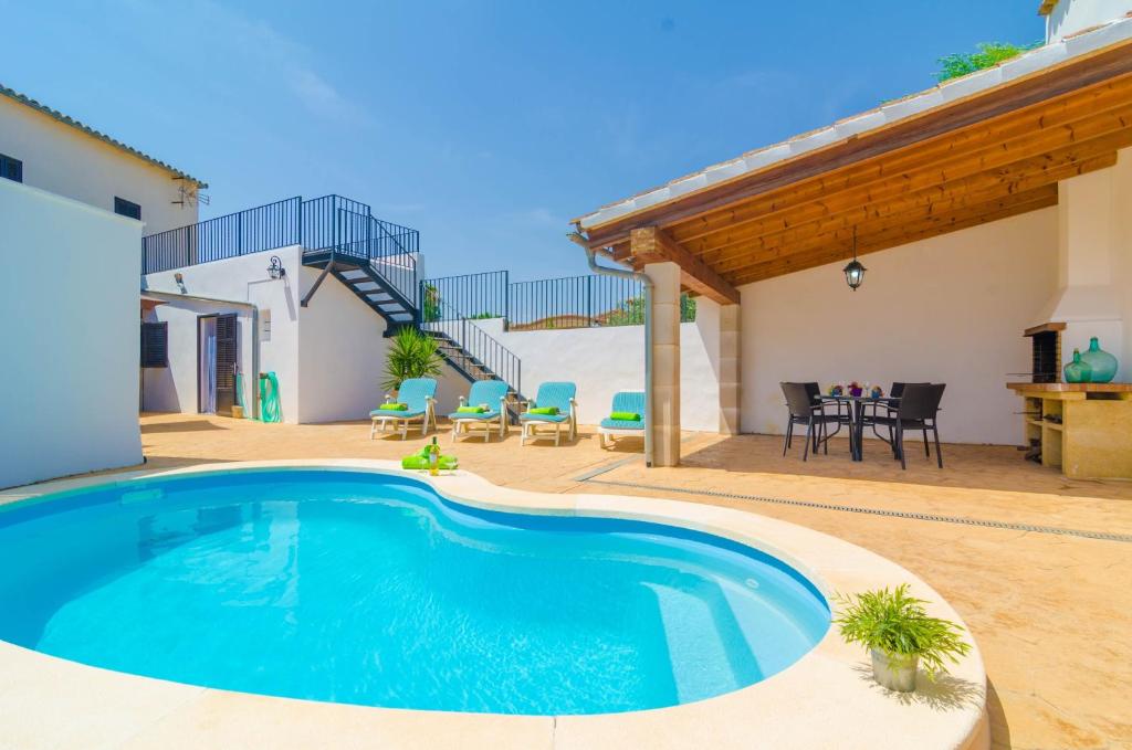 una piscina en medio de un patio con mesa y sillas en Can Pistola, en Algaida