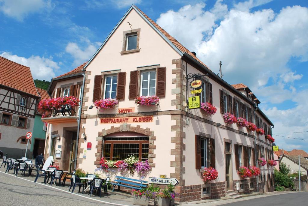 a building with flower boxes on the side of a street at Hôtel Restaurant Kleiber in Saint-Jean-Saverne