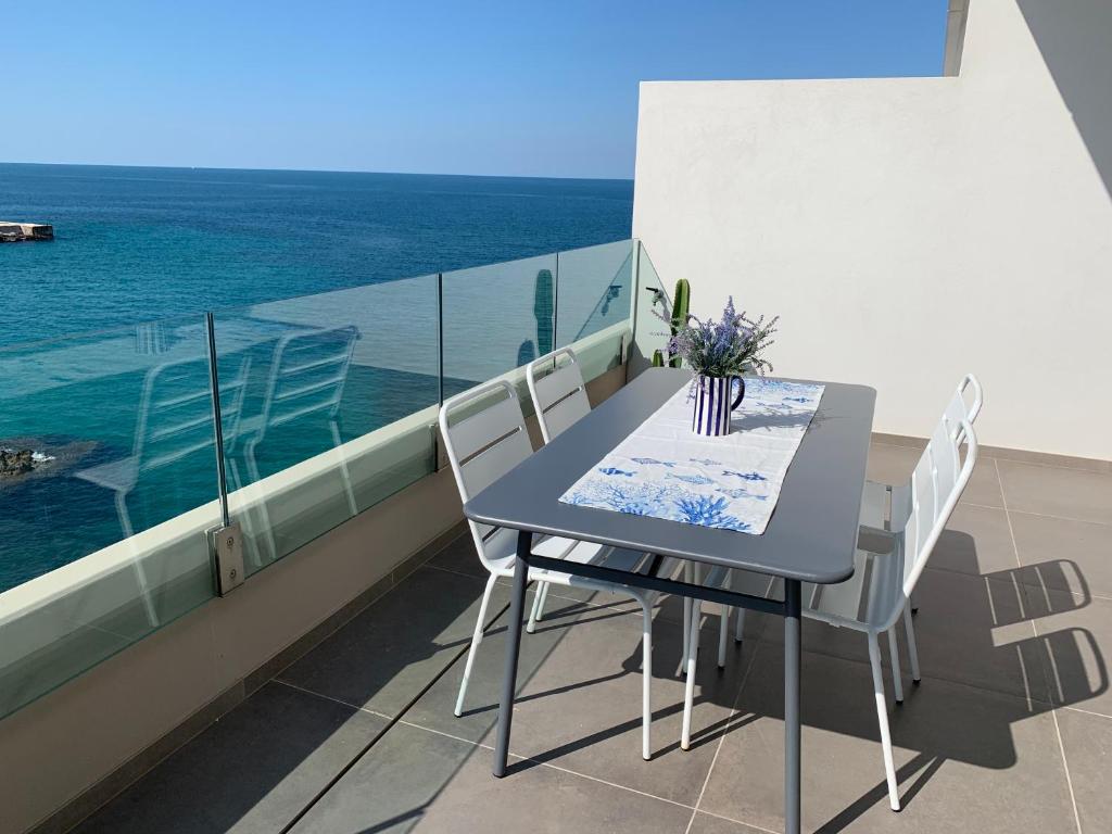 einen Tisch und Stühle auf einem Balkon mit Meerblick in der Unterkunft Fly on the Sea in Monopoli