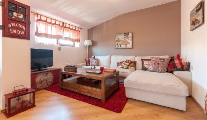Mountain Paradise 4 Apartments في بانسكو: غرفة معيشة مع أريكة بيضاء وتلفزيون