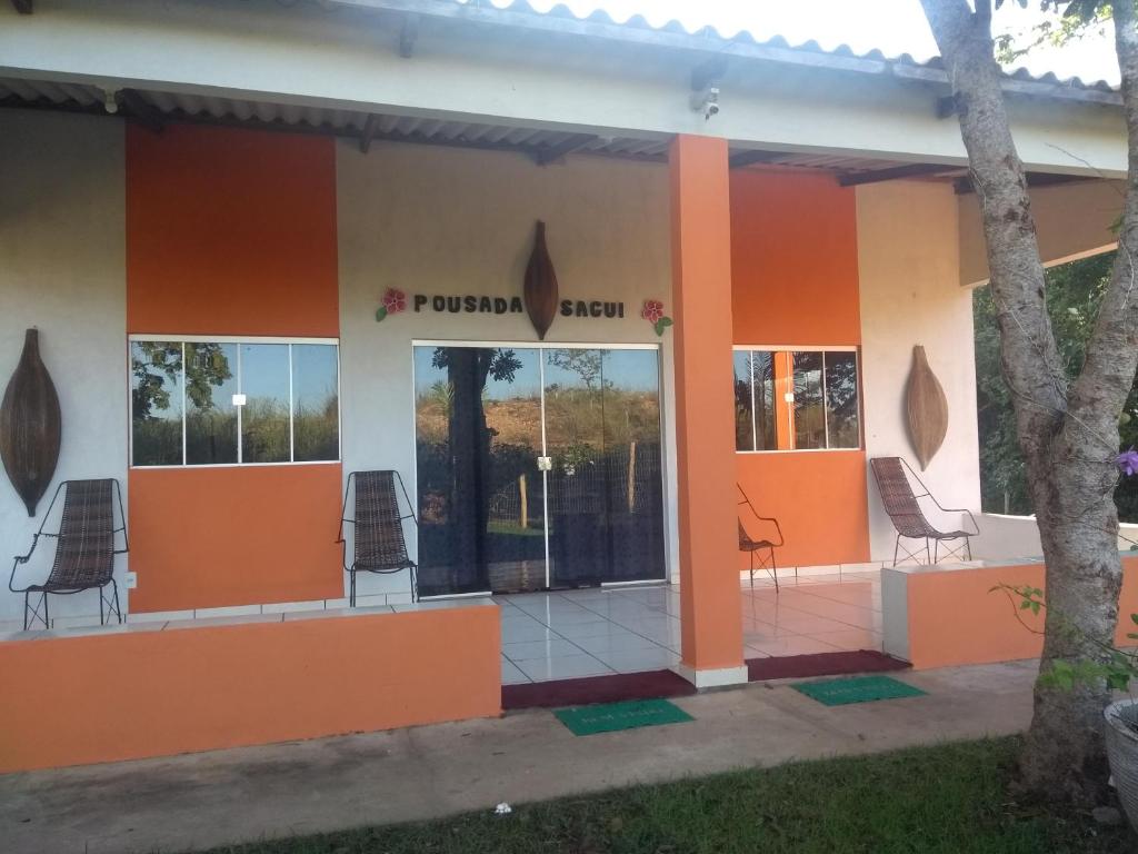 a building with chairs outside of it at Chácara Pousada Sagui in Cuiabá