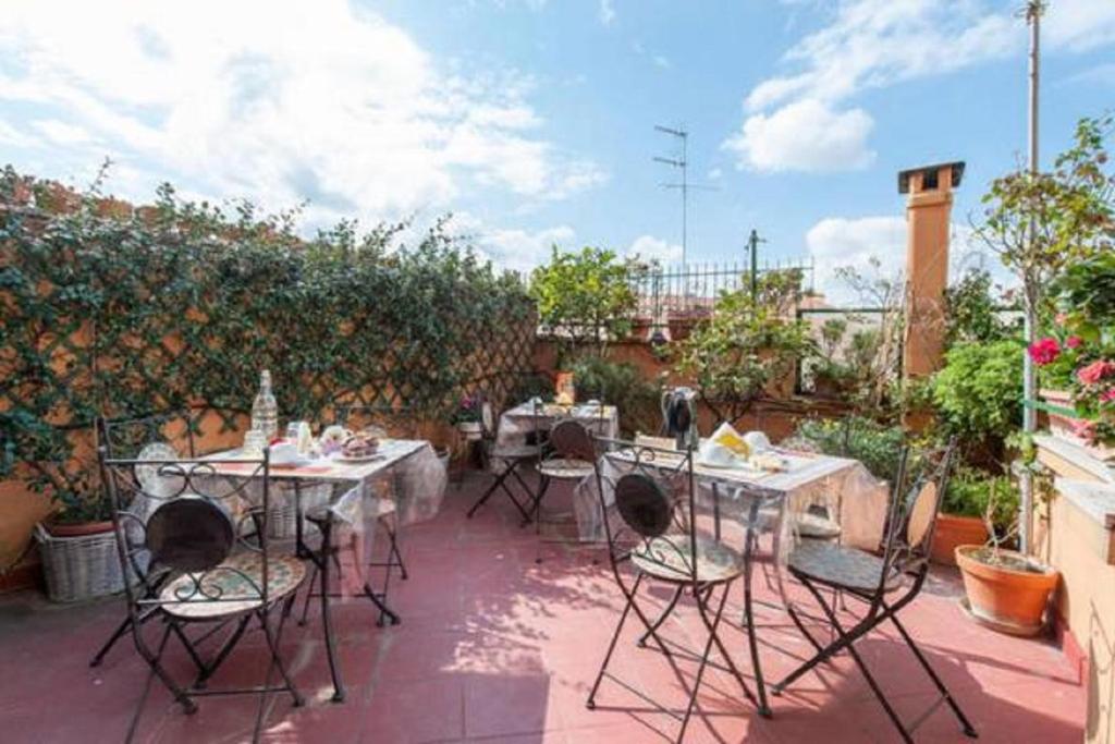 a patio with tables and chairs in a garden at Casa Via Cesena in Rome