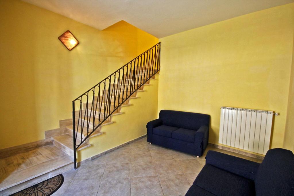 un soggiorno con scala e sedia blu di Il Cantinone Rooms a Castelnuovo di Farfa