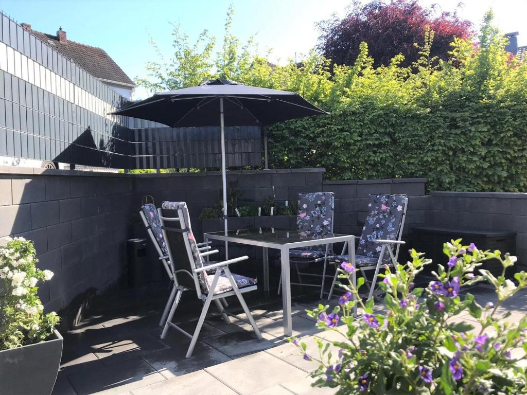 a table and two chairs and an umbrella in a garden at Ferienhaus Adele in Bad Neuenahr-Ahrweiler