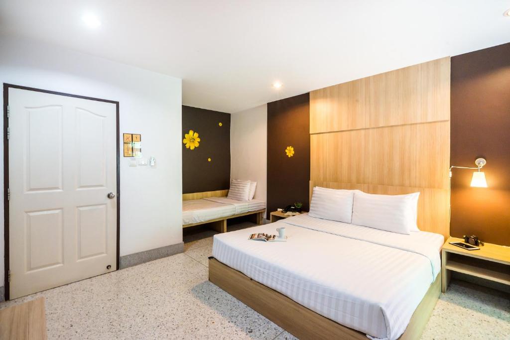 Habitación de hotel con cama y dormitorio con banco en The Fifth Residence en Bangkok
