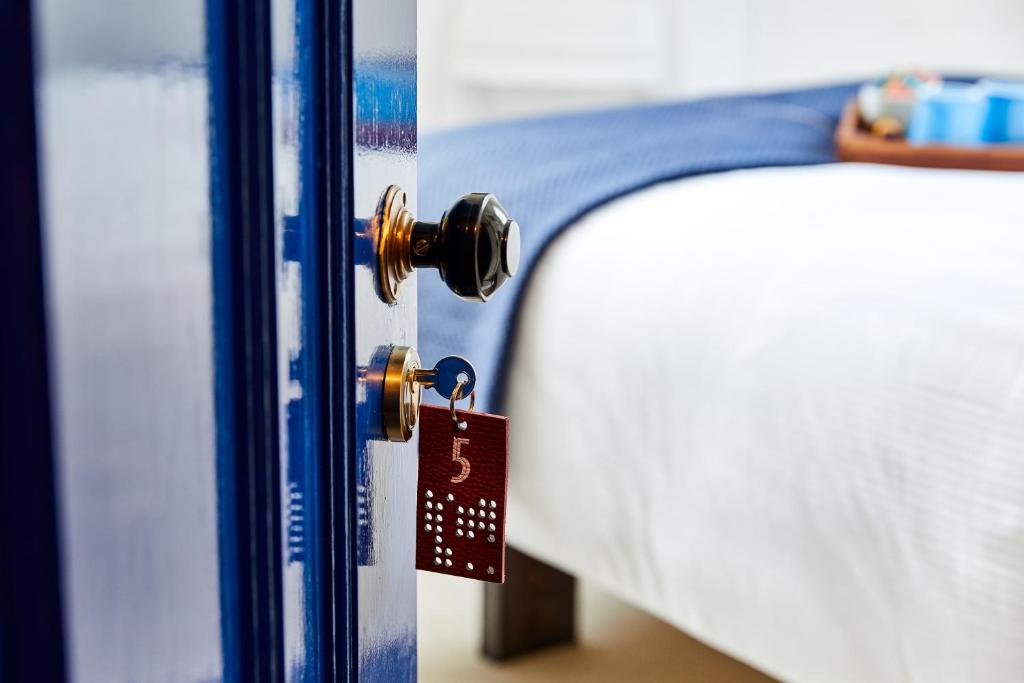 una etiqueta colgando de la puerta de una cama en The Buxton, en Londres