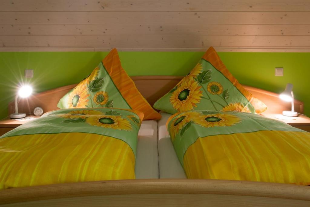 a bedroom with two beds with yellow and green pillows at Riehle Hof in Zell am Harmersbach
