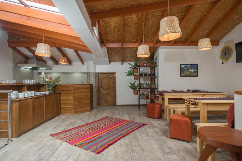 库斯科Casa Matara Boutique的客厅设有木制天花板和桌椅