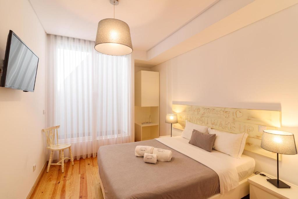 1 dormitorio con 1 cama grande y 2 toallas. en Lindo Vale Guest House, en Oporto