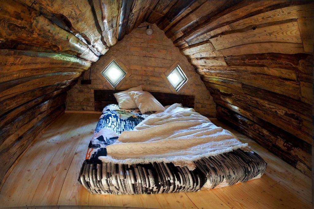 uma cama num quarto num chalé de madeira em Ventspils Garden house em Ventspils