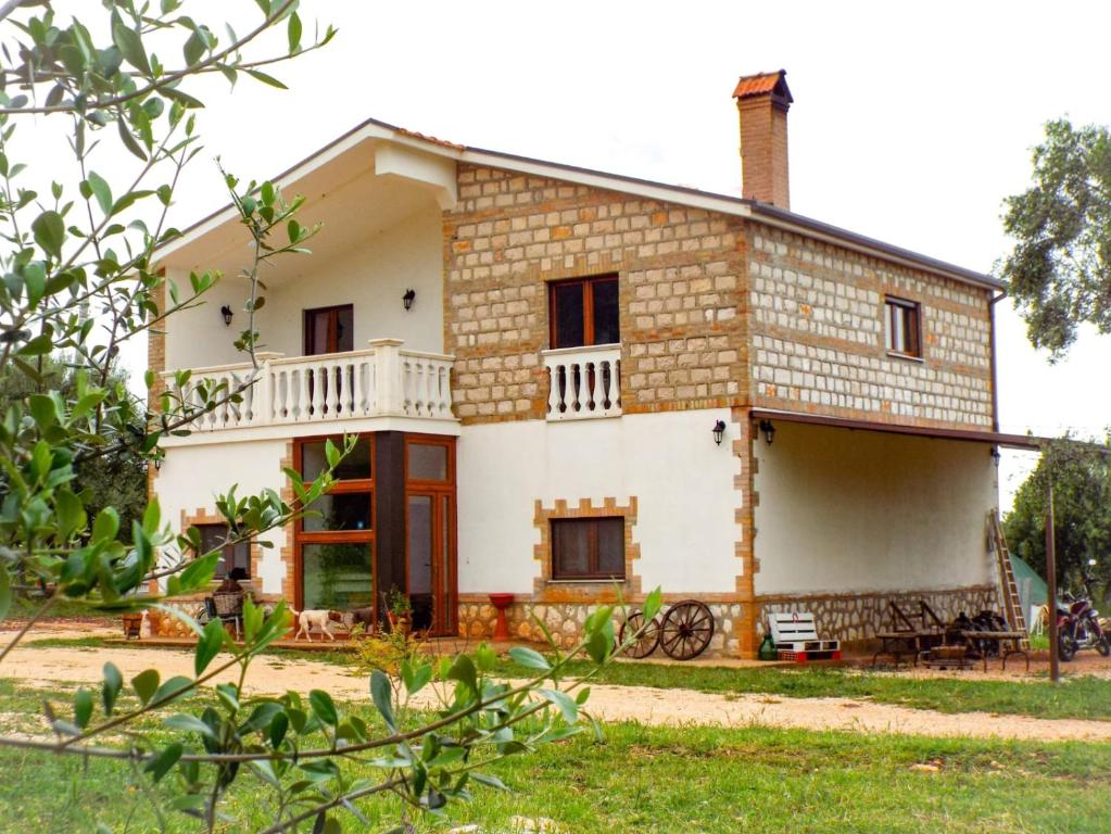 Cette grande maison blanche dispose d'une terrasse couverte. dans l'établissement Gio Horses B&B, à San Nicandro Garganico