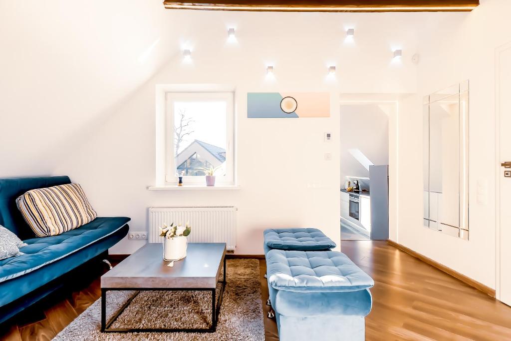 a living room with a blue couch and a table at Stylish, modern apartment near Vilnius Old Town in Vilnius