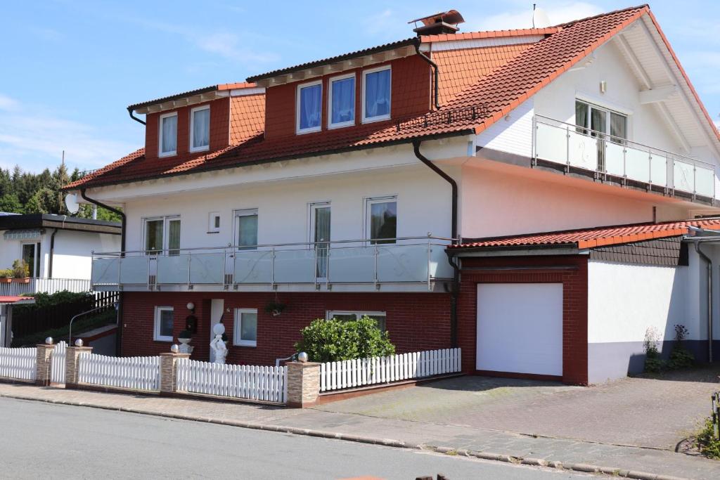 a white and red house with a garage at Ferien- und Monteurwohnung Julia in Mörlenbach