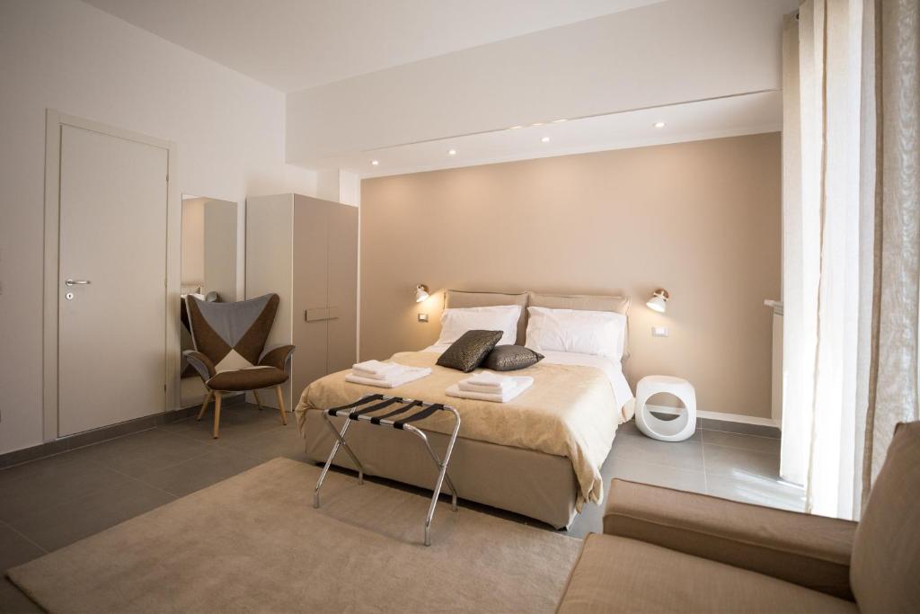 ein Schlafzimmer mit einem großen Bett und einem Stuhl in der Unterkunft Prometeo rooms in Syrakus