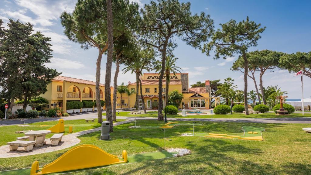 a park with playground equipment in front of a building at Macdonald Leila Playa Resort in La Cala de Mijas