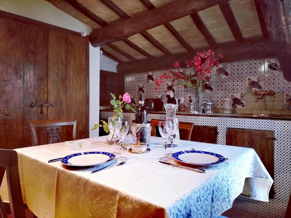 une table avec un chiffon de table blanc et des verres dessus dans l'établissement Sotto i tetti del borgo, à Spolète