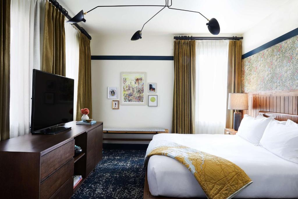 um quarto com uma cama e uma televisão de ecrã plano em Hotel Revival Baltimore em Baltimore