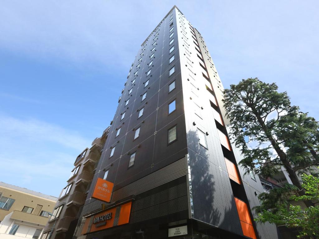 un grand bâtiment avec une façade noire et blanche dans l'établissement APA Hotel Ginza-Takaracho Tokyo Yaesu Minami-guchi, à Tokyo