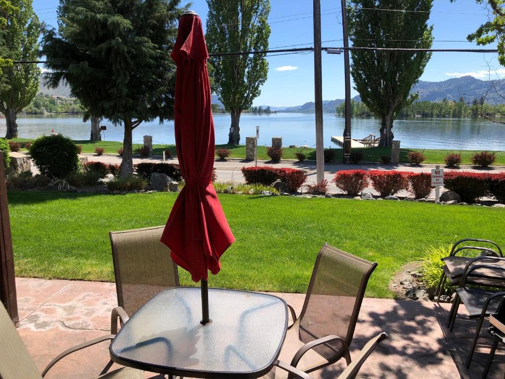a red umbrella sitting on top of a table at Lakefront Townhouse Family Complex, Popular Wine Country and the Best Golfing in Osoyoos