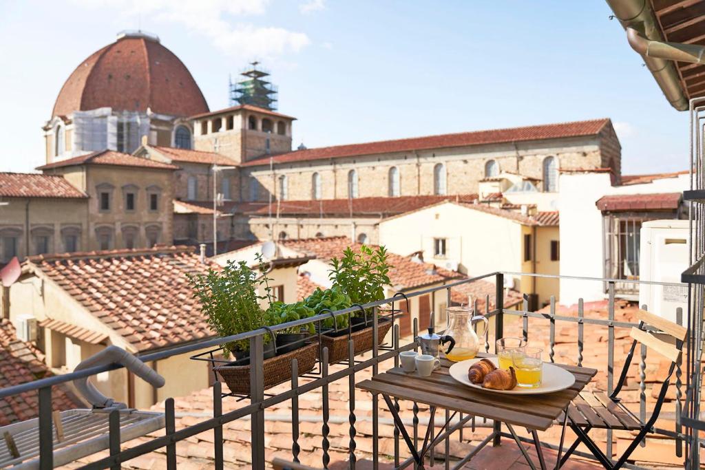 una mesa en un balcón con vistas a la ciudad en One of a kind Near The Duomo w/Balcony Palace Apt, en Florencia