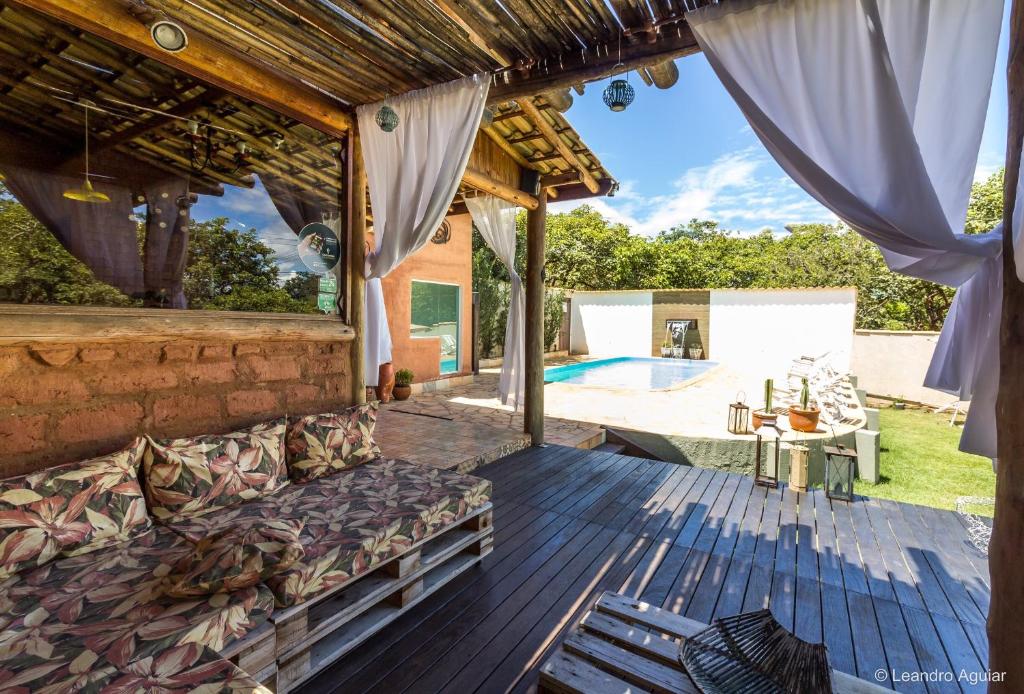 a patio with a couch on a deck with a pool at Pousada Pepalantus in Serra do Cipo