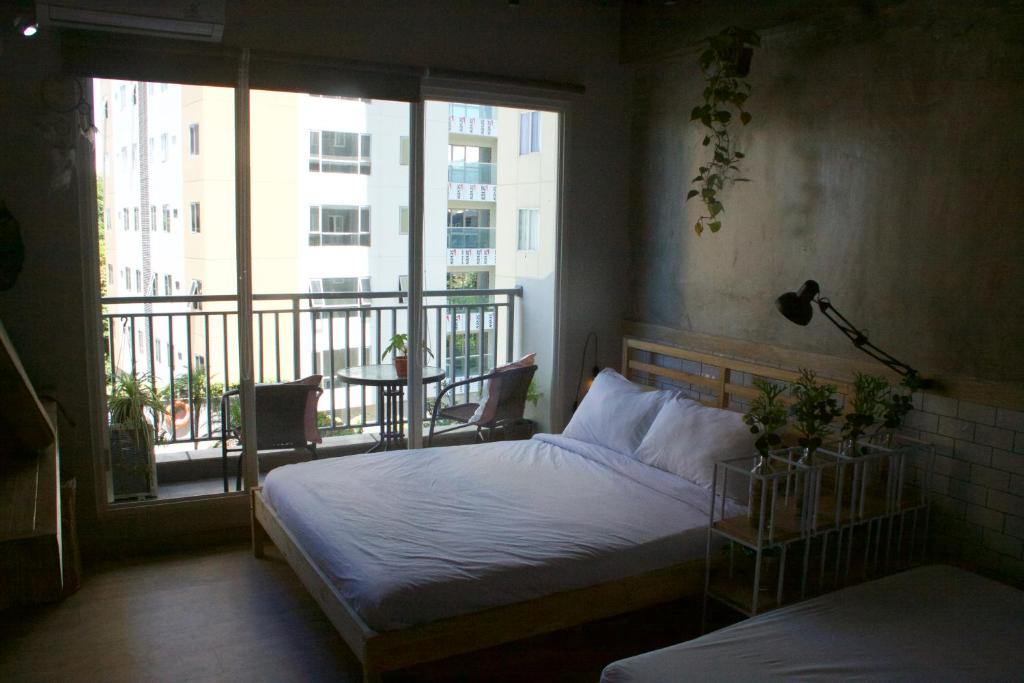 a bedroom with a bed and a balcony at DreamWood @ Galeri Ciumbuleuit in Bandung