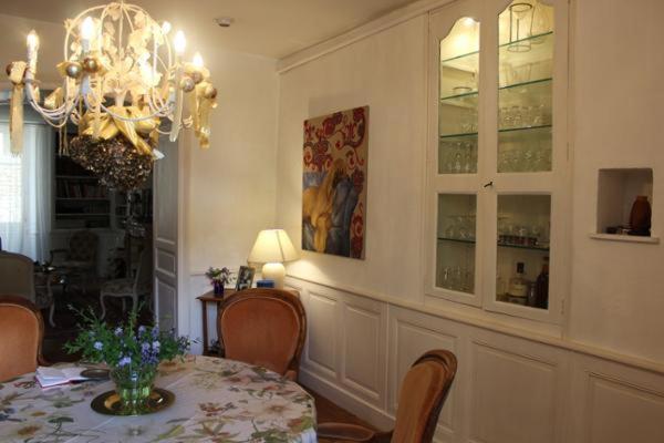 a dining room with a table and chairs and a chandelier at Le Magnolia in La Rochefoucauld