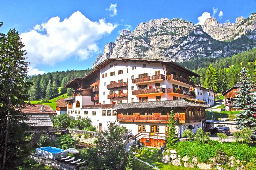 a large building in front of a mountain at Hotel Dolomiti in La Villa