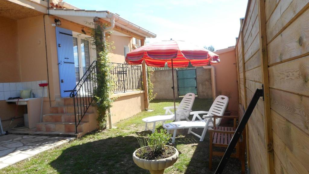 a patio with two chairs and an umbrella at La Cigale in Malaucène