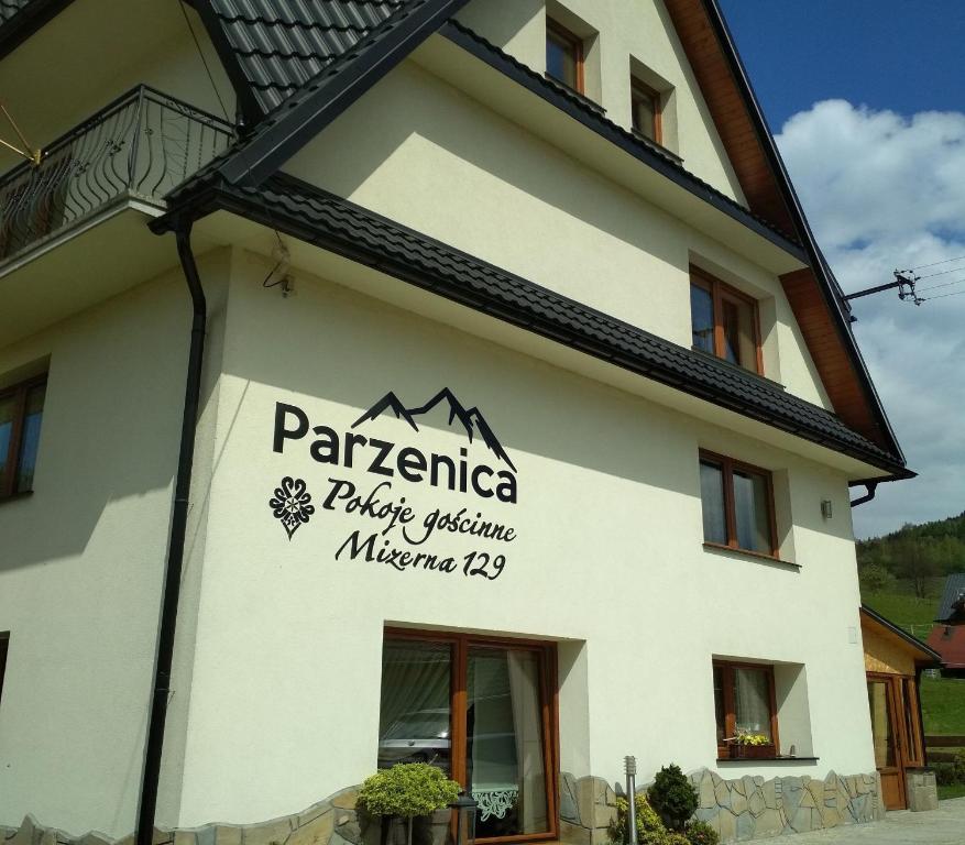 a building with a sign on the side of it at Pokoje Goscinne Pieninska Parzenica in Mizerna