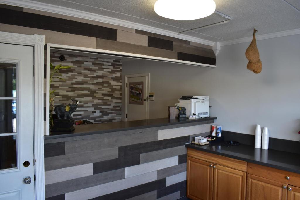 cocina con encimera y pared de ladrillo en Inn of Lenoir Motor Lodge en Lenoir City