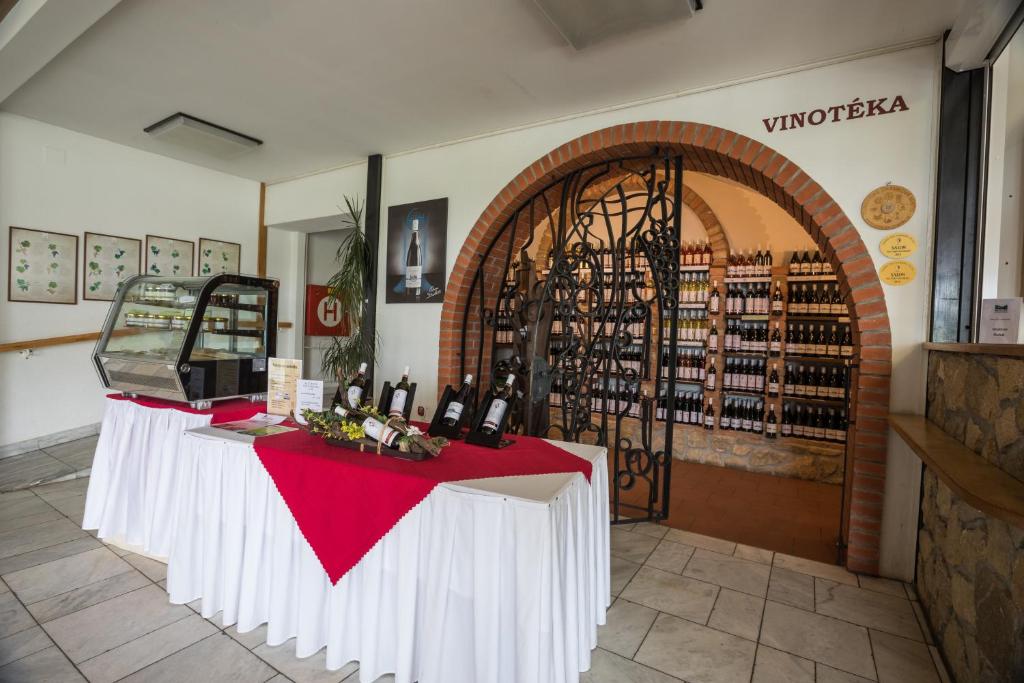 una tienda de vinos con 2 mesas y botellas de vino en Penzion Patria Kobyli, en Kobylí