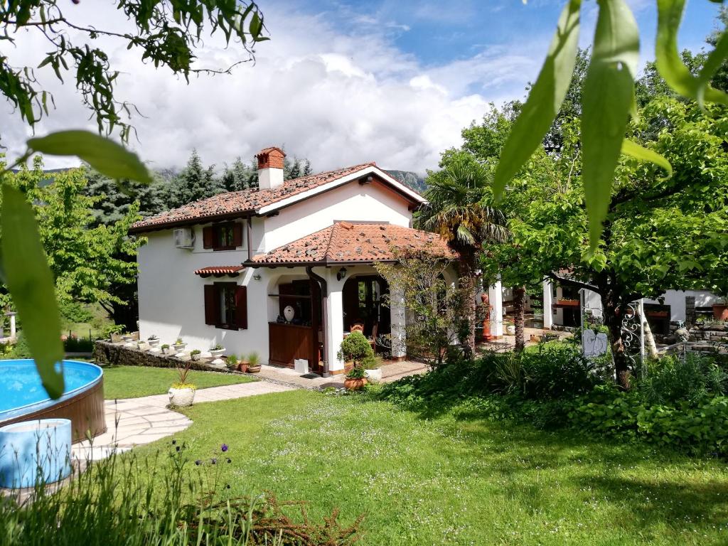 mały biały dom na podwórku z ogródkiem w obiekcie Apartment Slavi w mieście Vipava