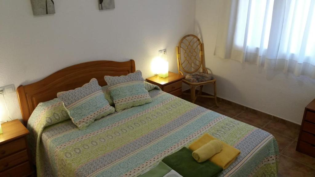 una camera da letto con un letto e due asciugamani di Apartamentos Les Palmeres a Platja  d'Aro