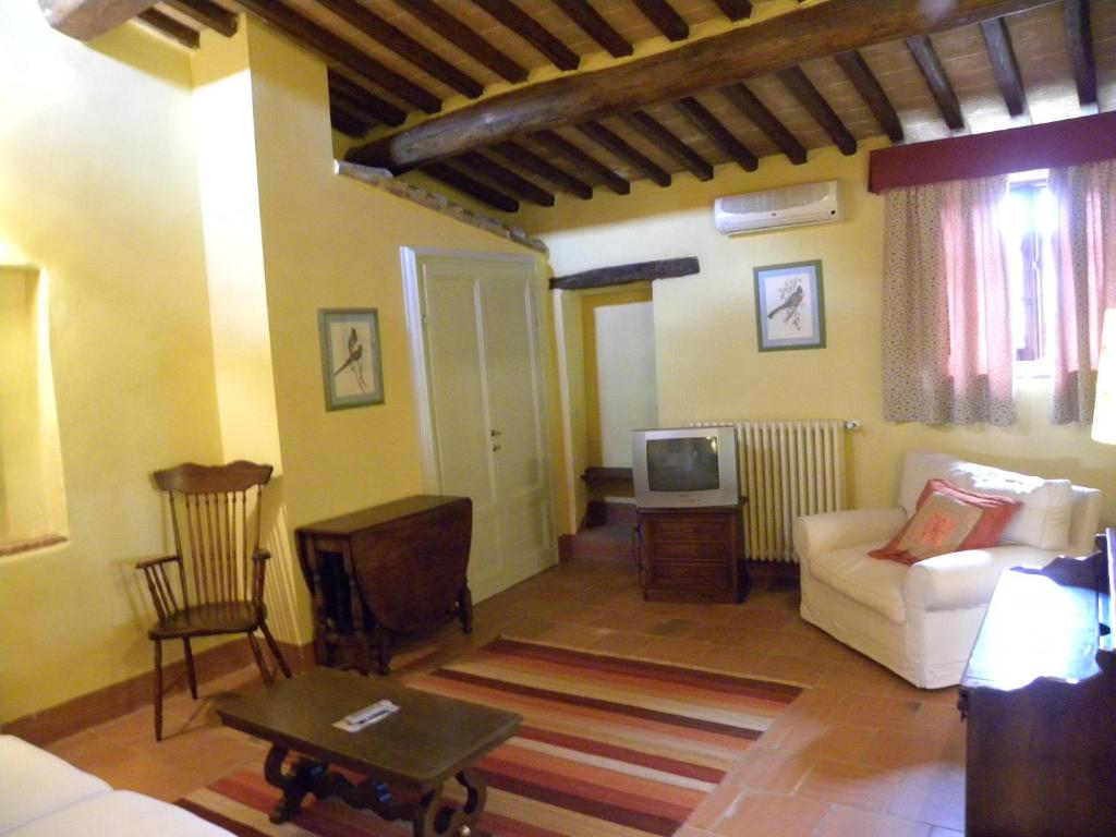 salon z kanapą i telewizorem w obiekcie Torraccia di Chiusi Agriturismo Relais w mieście San Gimignano