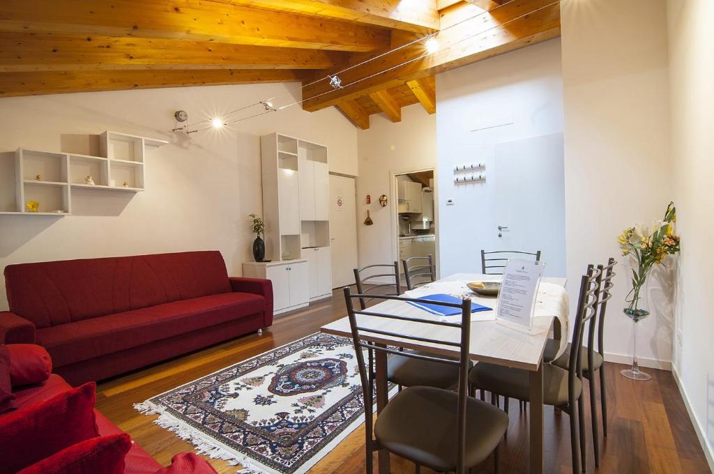 維洛納的住宿－Dimore Verona Residenza Zeno，客厅配有桌子和红色沙发