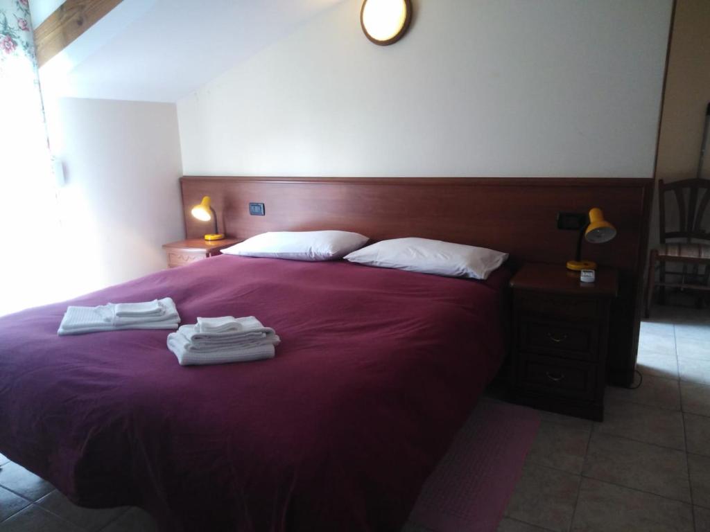 a bedroom with a purple bed with towels on it at La Pineta in Albenga