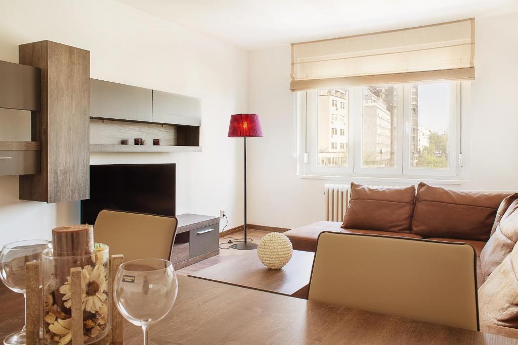 ein Wohnzimmer mit einem Sofa und einem Tisch in der Unterkunft City Place Apartments in Belgrad