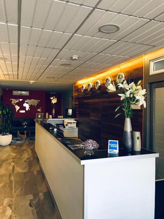 a lobby with a counter with flowers on it at ILLIA 121 APART HOTEL in Neuquén