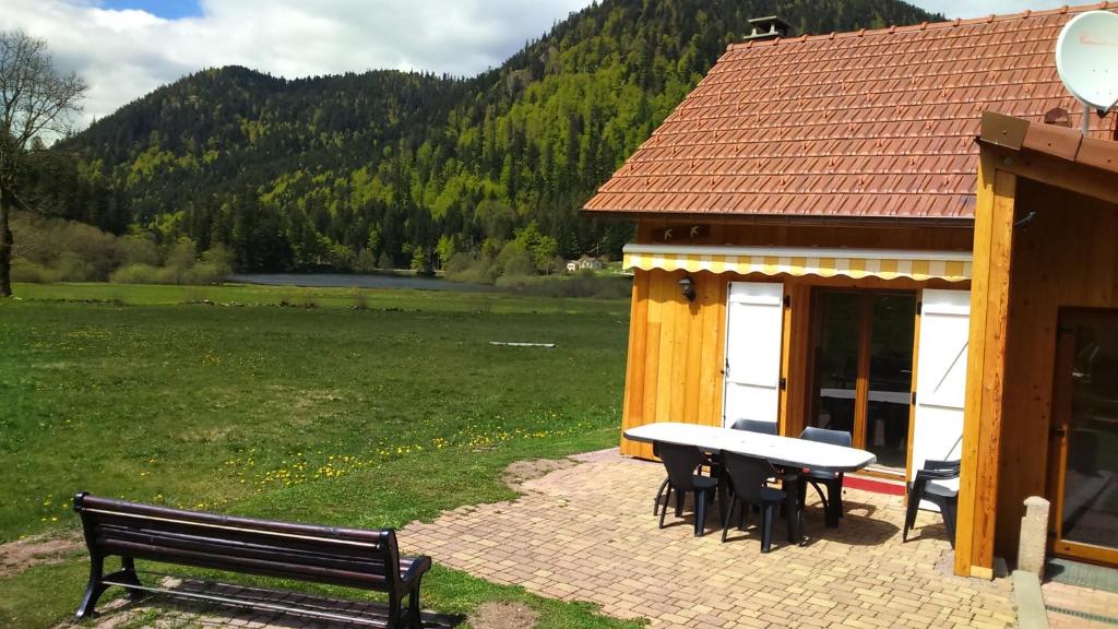 a building with a picnic table and a bench at Chalet pour amoureux de la nature avec vue sur le lac de Retournemer in Xonrupt-Longemer