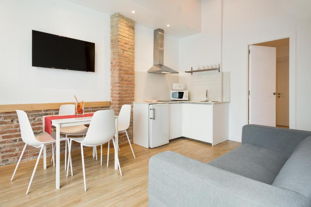 a living room with a couch and a table and chairs at BcnStop Parc Güell in Barcelona