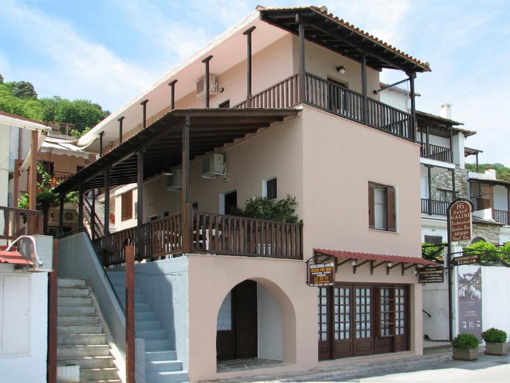 a large white building with a balcony and stairs at MARIA Studios & Apartments in Agios Ioannis Pelio