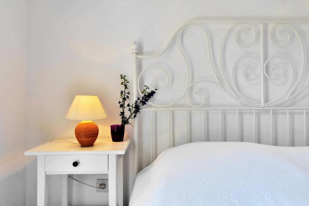 a bed with a white headboard and a table with a lamp at Luka's House - Hvar in Hvar