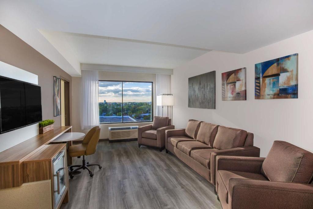 a living room with a couch and a flat screen tv at Wyndham Garden Ft Lauderdale Airport & Cruise Port in Dania Beach