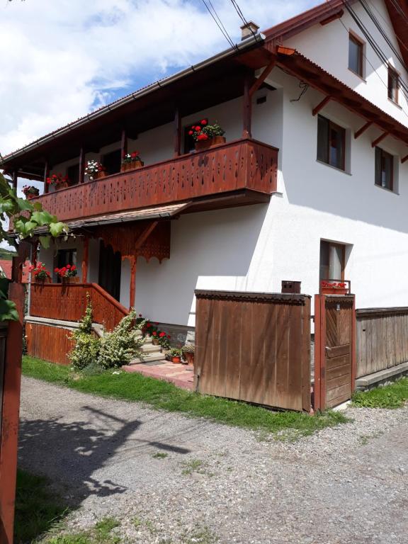 Cette maison blanche dispose d'un balcon fleuri. dans l'établissement Molnár Vendeghaz, à Praid