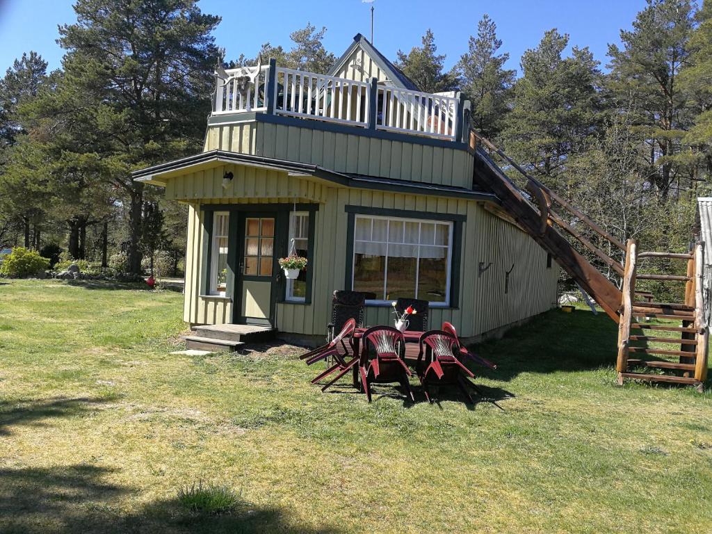 een klein huis met een tafel en stoelen in de tuin bij Kukka Holiday House in Kukka