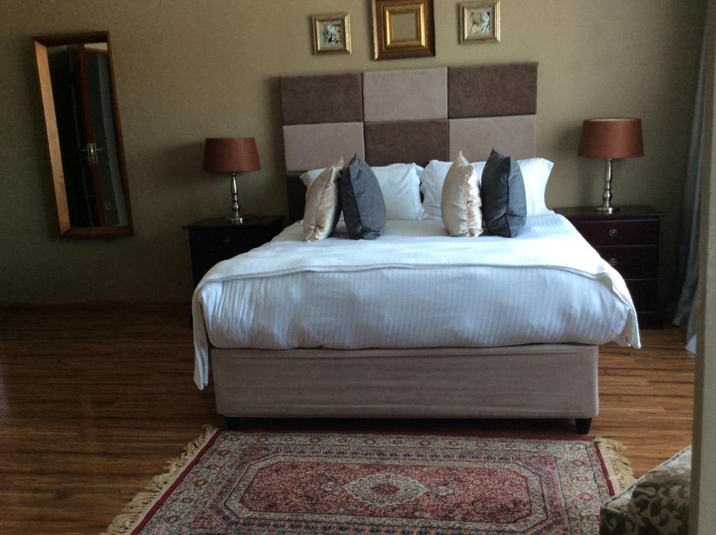 - une chambre avec un grand lit et des oreillers dans l'établissement 23 on Camden Guest House, à East London