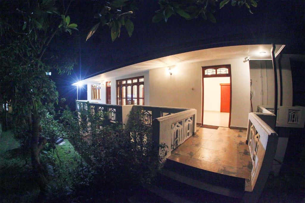 een huis 's nachts met een veranda en een deur bij 12 B Lewella Road, Kandy. in Kandy
