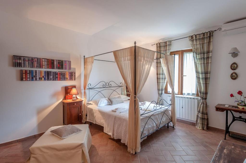 um quarto com uma cama de dossel e uma mesa em Le Tartarughe rooms em Magliano in Toscana